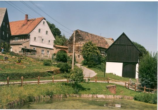 Blick über den Dorfteich zu einem Bauernhof