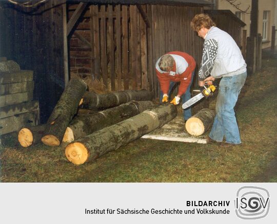 Ein Dresdner Korbmacher (rechts) beim Zuschneiden des Holzes in Ohorn