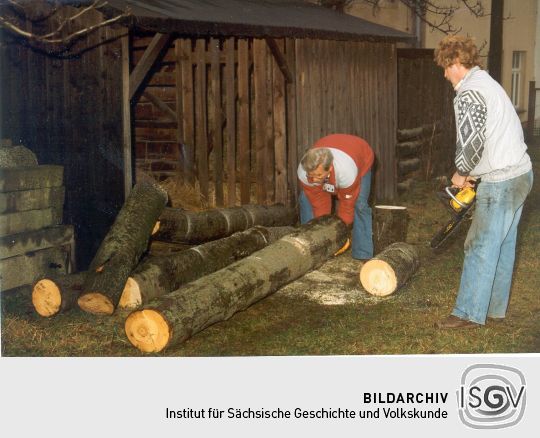 Ein Dresdner Korbmacher (rechts) beim Zuschneiden des Holzes in Ohorn