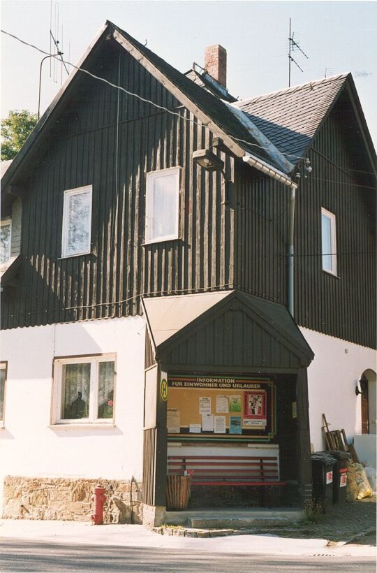 Buswartehäuschen an einem Deutschgeorgenthaler Wohnhaus