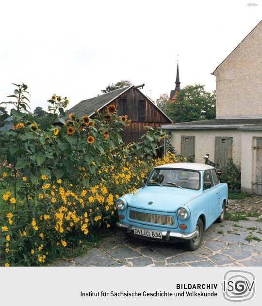 Hof mit Fahrzeug und Blumen in Marieney