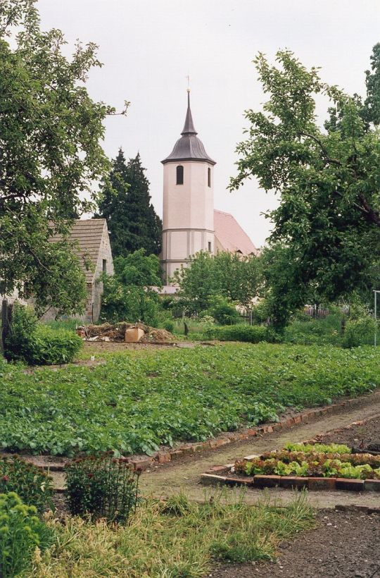 Kirche in Taura über ein kleines Feld gesehen