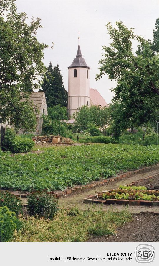 Kirche in Taura über ein kleines Feld gesehen