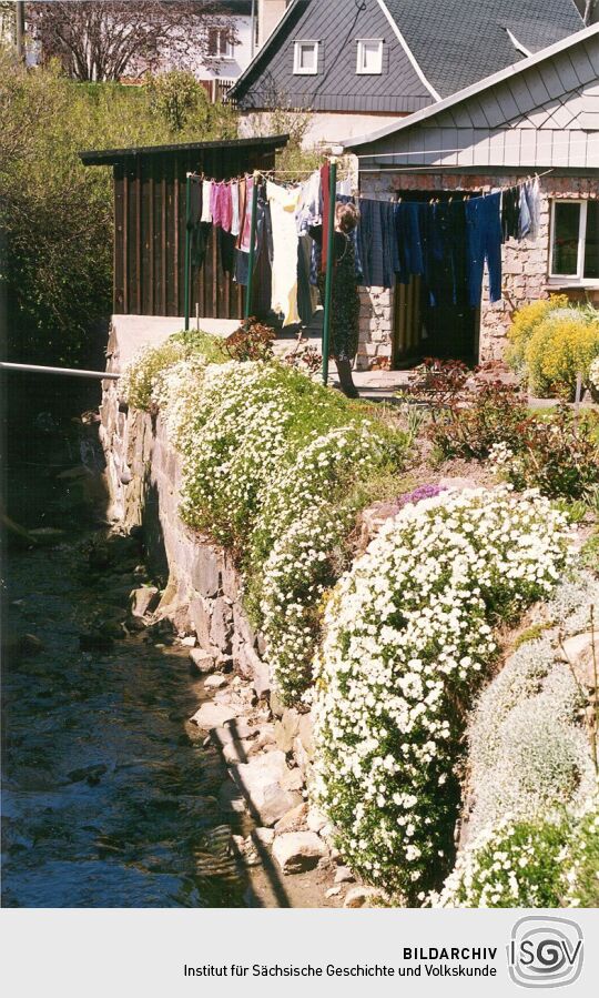 Mit Blumen verzierte Ufermauer in Obercunnersdorf