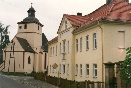 Blick auf die Kirche und Blick auf ein Wohngebäude in Auligk