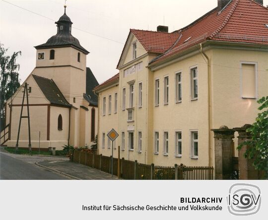 Blick auf die Kirche und Blick auf ein Wohngebäude in Auligk