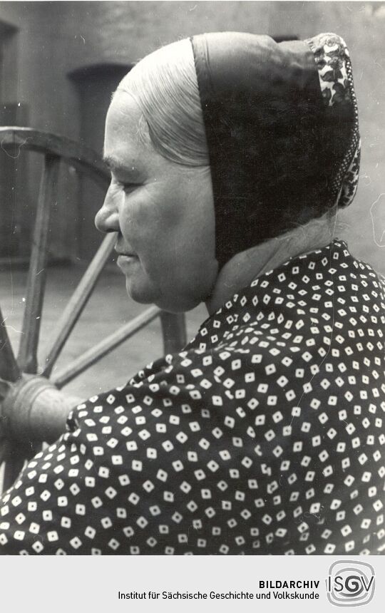 Frau aus Bluno am Spulrad