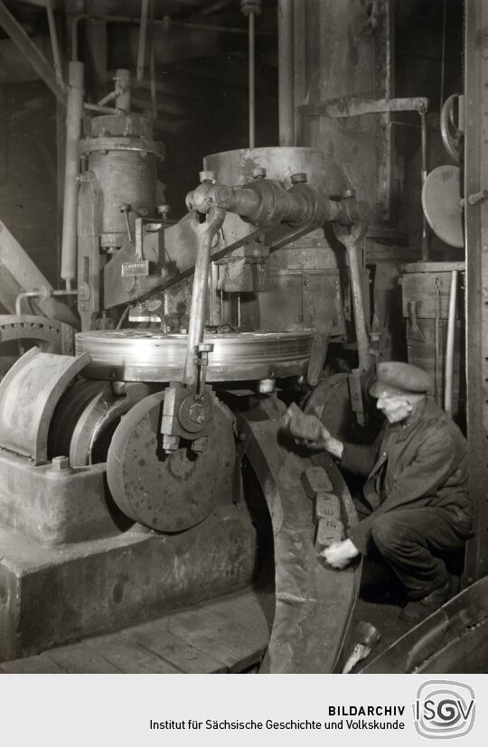 Arbeiter an einer Brikettpresse in Zwickau