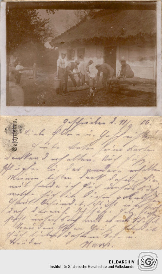 Postkarte mit einem aufgeklebten Foto von Soldaten an einer Feldküche