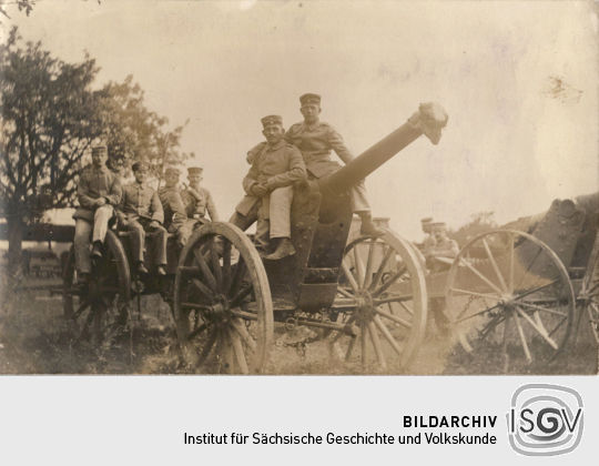 Postkarte: Soldaten posieren auf einem Geschütz