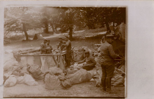 Postkarte: Soldaten beim Sortieren von Post im Freien