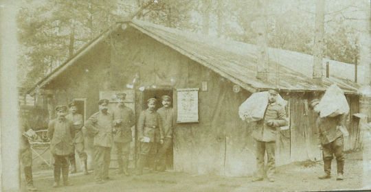 Soldaten der Feldpost vor einer Baracke