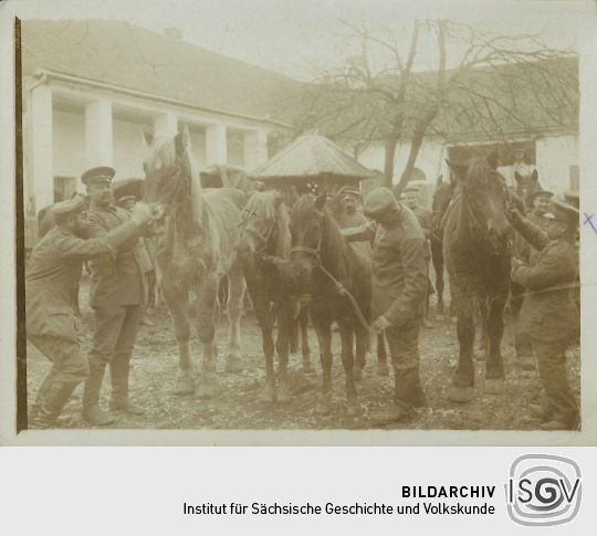 Soldaten der Feldpost mit Pferden in einem Hof