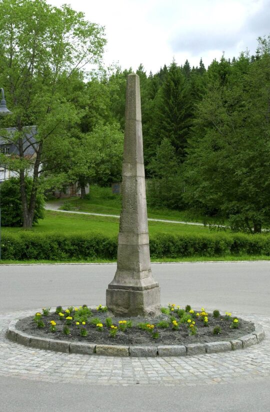 Postmeilensäule auf einer Verkehrsinsel in Erlabrunn