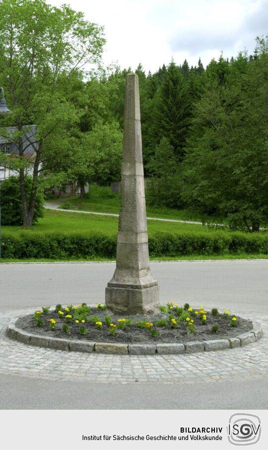 Postmeilensäule auf einer Verkehrsinsel in Erlabrunn