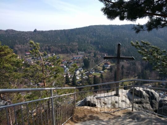 Das 2006 auf dem Oybin errichtete Gipfelkreuz mit Blick über den Ort Oybin zum Scharfenstein.