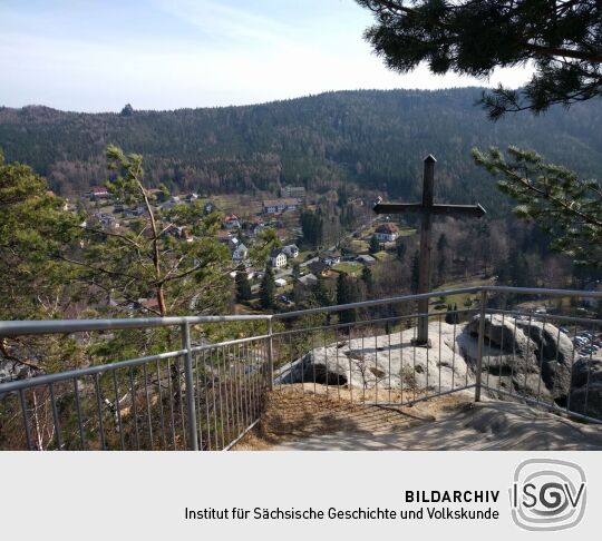 Das 2006 auf dem Oybin errichtete Gipfelkreuz mit Blick über den Ort Oybin zum Scharfenstein.