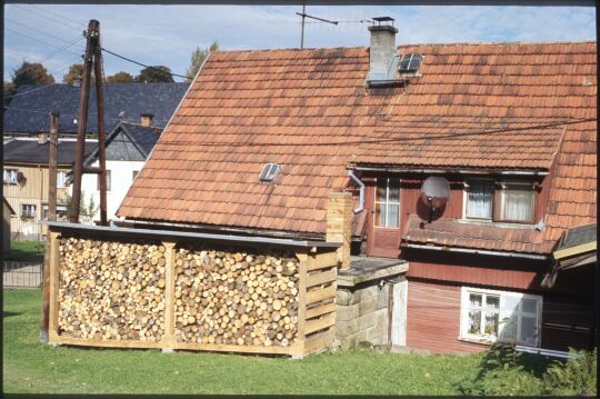 Gebäude in Saupsdorf mit einem Gestell zur Aufbewahrung von Holz zum Heizen.