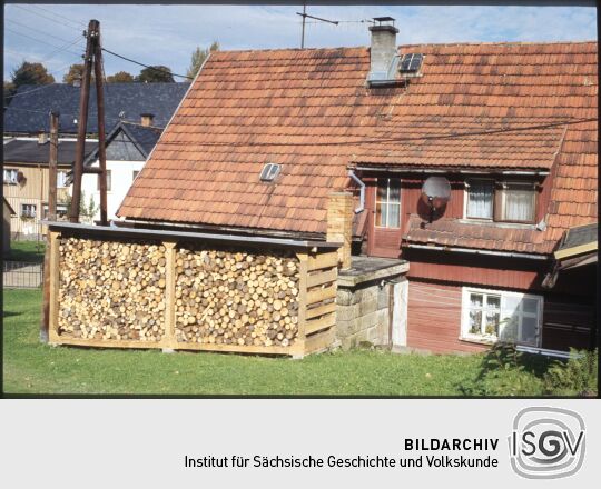 Gebäude in Saupsdorf mit einem Gestell zur Aufbewahrung von Holz zum Heizen.