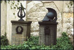 Bild: Zwei Gräber auf dem katholischen Friedhof in der Dresdner Friederichstadt. Die Grabsteine sind mit einer Lyra und einem antiken Helm geschmückt.