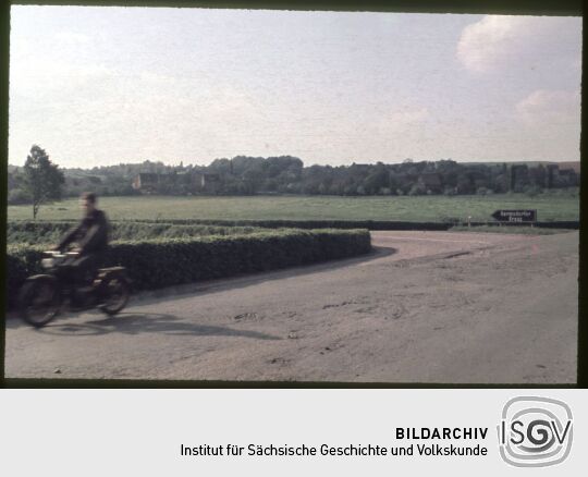 Kreuzung mit Motoradfahrer in Weidensdorf mit einem Wegweiser zum Hermsdorfer Kreuz