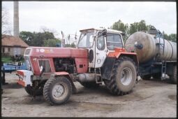 Bild: Traktor der LPG Großwelka mit einem Tankwagen. Der Traktor ist unter anderem mit aufklebern westlicher Unternehmen beklebt.