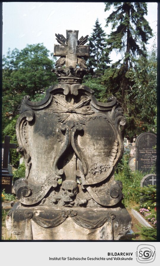 Blick auf ein Grabstein mit Rokokokartuschen auf dem Neustädter Friedhof in Dresden