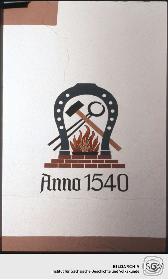 Wandbild mit Hufeiesen, Hammer, Zange, Feuer und der Jahreszahl 1540 in Freiberg
