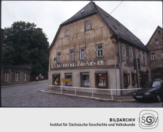 Fahnengeschmücktes Fachwerkgebäude mit einer Drogerie in Penig (Leipziger Straße 1)