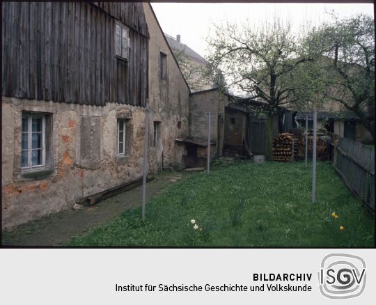 Wiese an einem Gebäude in Pulsnitz mit Frühlingsblumen