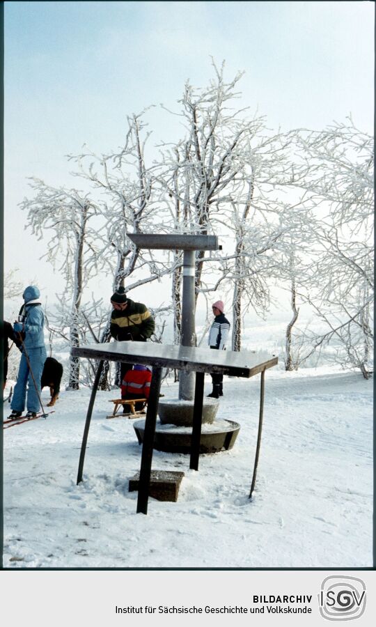 Verschneiter Kahleberg im Osterzgebirge mit Menschen auf Skiern und Schlitten und einem Fernrohr, 1986