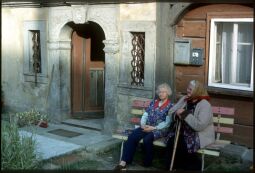 Bild: Zwei Frauen auf einer Bank vor einem Umgebindehaus mit Steinportal mit Rokokodekor in Waltersdorf 1994