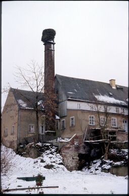 Bild: Verschneite Gebäude in Kleinröhrsdorf mit einem Storchennest auf einem Schornstein, 1993