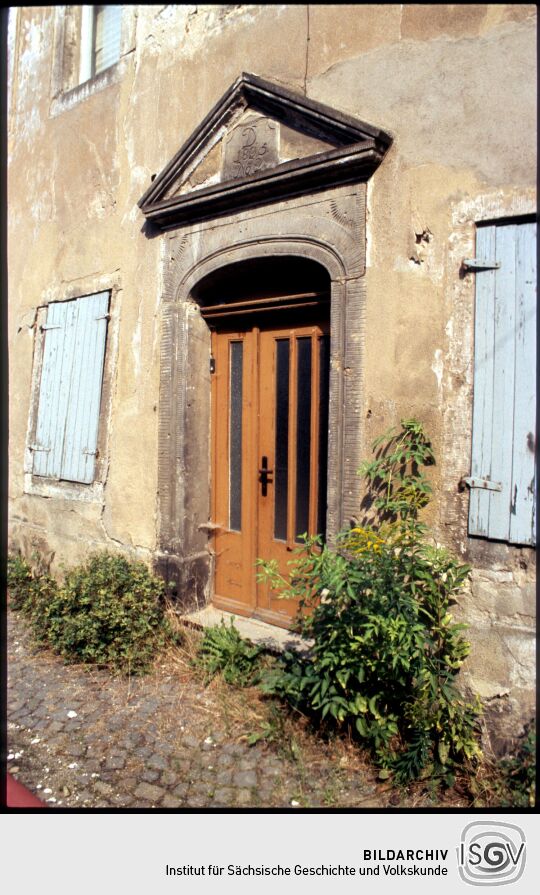 Hauseingang mit klassizistischer Steinfassung in Mügeln 1995. Das Portal ist im Giebel über der Tür auf das Jahr 1805 datiert.