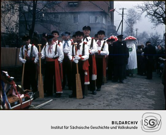 Umzug der Schifferfastnacht in Postelwitz 1959: Gruppe von Männern mit Schiffersmützen und Rudern