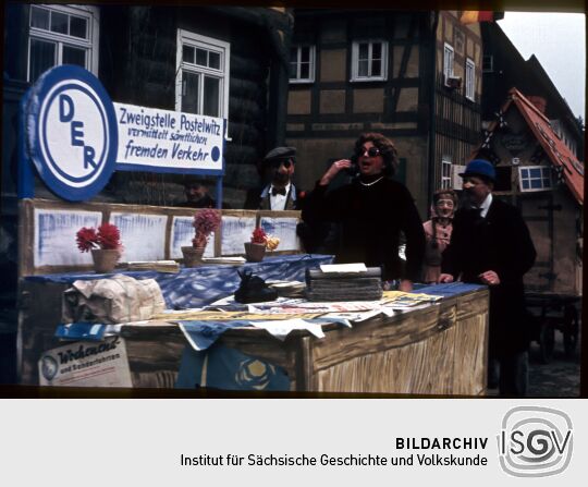 Umzug der Schifferfastnacht in Postelwitz 1959: Motivwagen mit einem nachgestellen Büro 'DER Zweigstelle Postelwitz vermittelt sämtlichen fremden Verkehr."