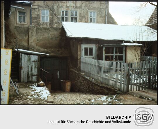 Verschneiter Hof in Bautzen mit einer Abfahrt zu einem Tor und einem Kleintierstal 1985