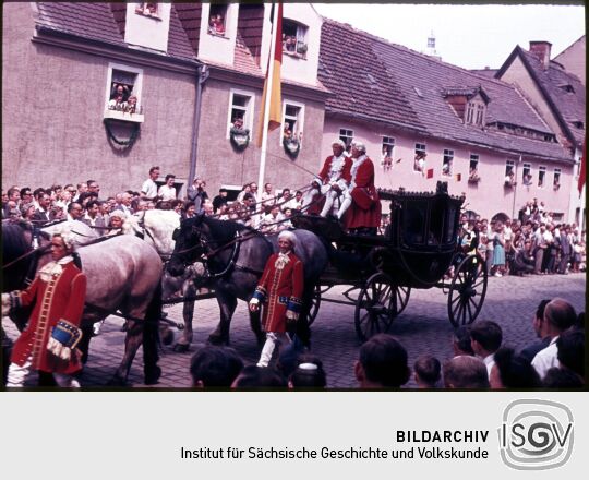 Teilnehmer eines Umzugs in Meißen in Kleidung des 18. Jh. mit einer historischen mehrspännigen Kutsche