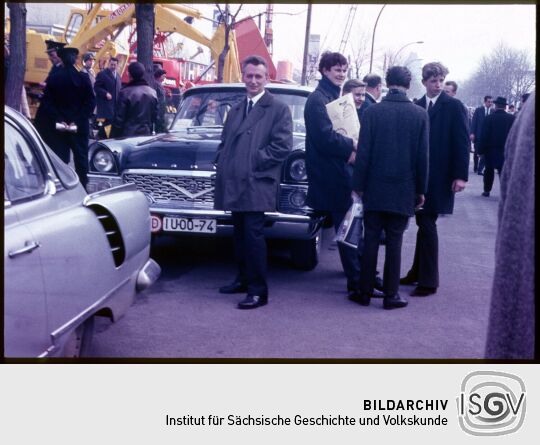 Besucher der Leipziger Messe 1967, im Hintergrund sind Bagger und da Leioziger Völkerschlachtdenkmal abgebildet