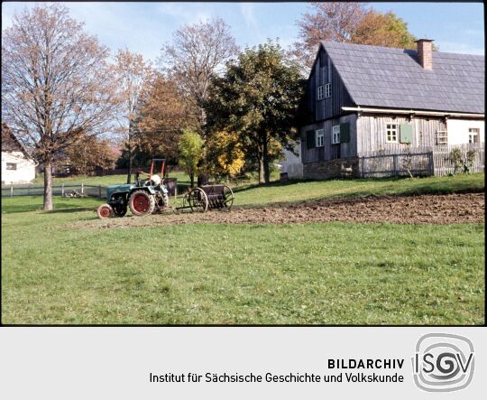 Traktor vor einem Gebäude in Landwüst
