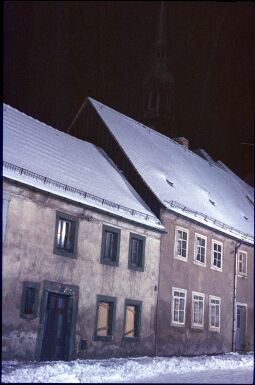 Bild: Blick durch eine verschneite Straße in Radberg bei Nacht.