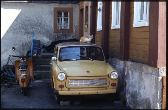Moped 'Simson' und ein Trabant mit einer Katze auf dem Dach