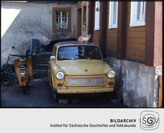Moped 'Simson' und ein Trabant mit einer Katze auf dem Dach