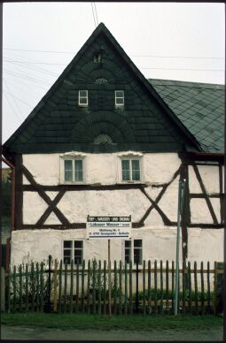 Bild: Werbeschild vor einem Fachwerkhaus mit verschiefertem Giebel