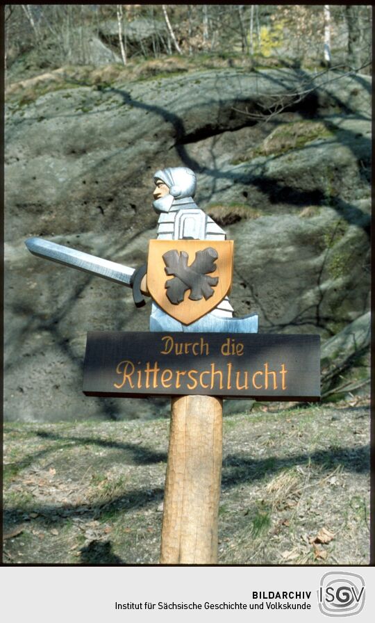 Wegweiser 'Durch die Ritterschlucht' mit einer Ritterfigur in Oybin