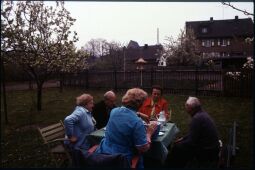 Bild: Fünf Personen an einer Kafeetafel in einem Garten