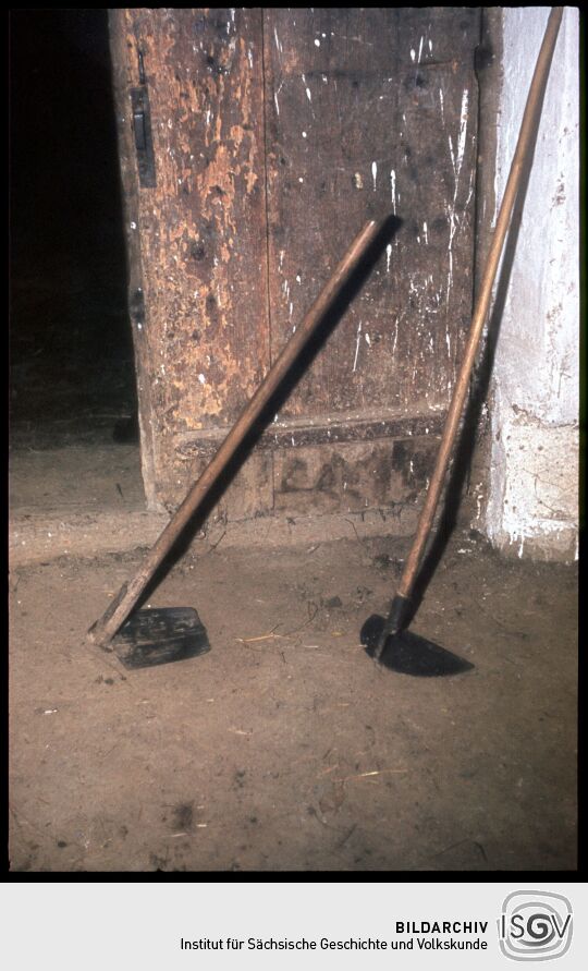 Zwei Hacken vor einer Tür in einem Bauernhof 1982