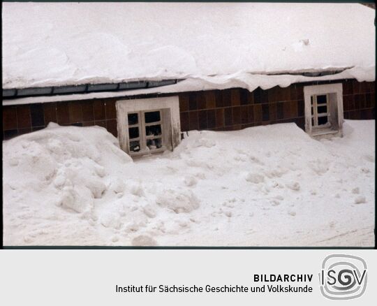 Fenster eines eingeschneiten Hauses in Zinnwald-Georgenfeld