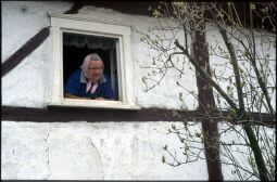 Bild: Frau mit Kopftuch an einem Fenster in Georgewitz