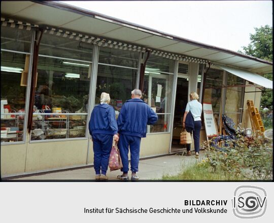 Drei Personen vor einem Geschäft (unbekannter Ort, evtl. Riesa)